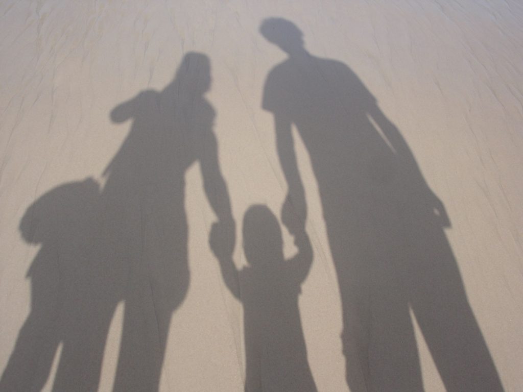 Schatten einer Familie im Sand