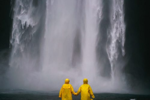 Paar hält Hände vor einem Wasserfall